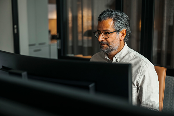 High angle view of mature businessman wearing eyeglasses working on computer at office desk